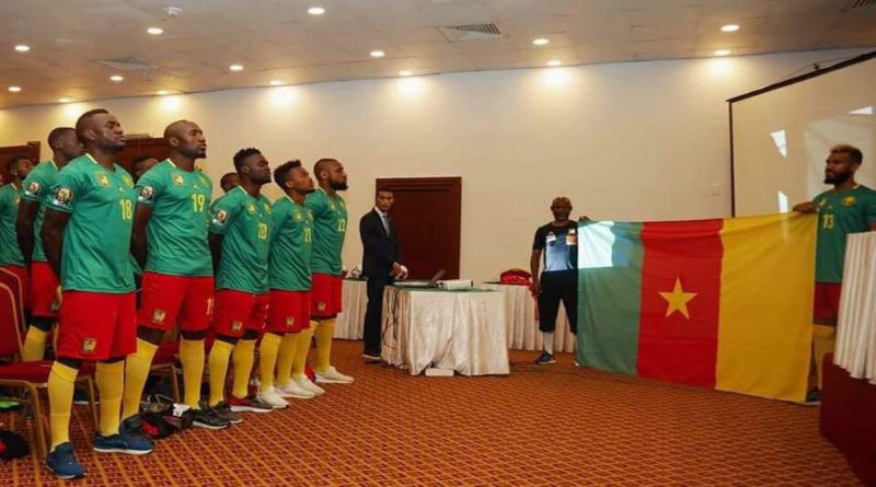 Lions indomptables du Cameroun devant le drapeau national